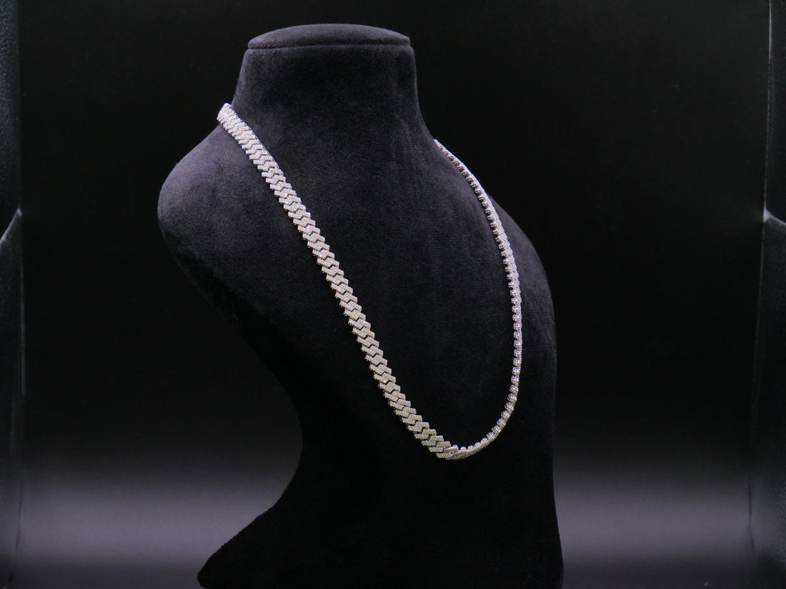 Pearl necklace on a black mannequin bust against a dark background