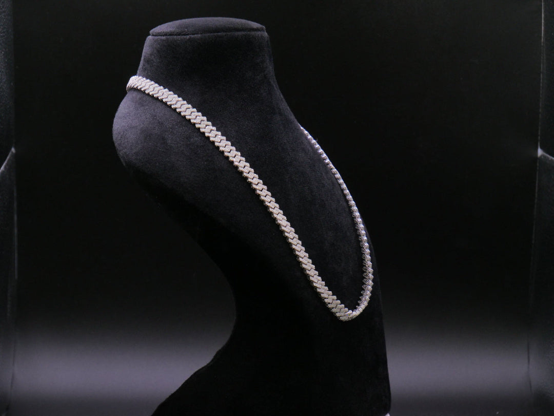 Pearl necklace on a black mannequin bust against a dark background